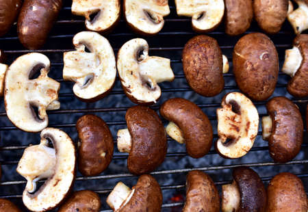 Champignon Mushroom on grilled. Cooking Agaricus bisporus White Mushrooms on hot charcoal and fire. Barbecue grill vegetables on flames.の写真素材