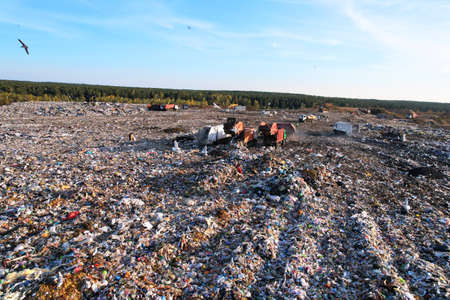 Landfill waste disposal. Garbage dump with waste plastic and polyethylene. Garbage truck unloads...