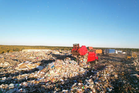 Landfill waste disposal. Garbage dump with waste plastic and polyethylene. Garbage truck unloads...