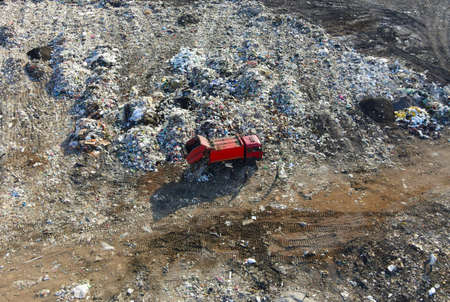 Garbage dump with food waste. Arial view of garbage truck unloads rubbish in landfill. Plastic...