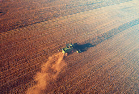 Combine harvester working on harvesting rapeseed, aerial view. Farm Harvest season in rural. Harvester for agriculture work. Harvesting oil seed rape (canola) in a field. Cutting crop in a farmland.の写真素材
