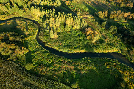 River in the wild. Aerial view of small river in middle of green forest in the wildlife. Natural Resource and Ecosystem. Wildlife Refuge Wetland Restoration. European Green Nature Scenery.の写真素材