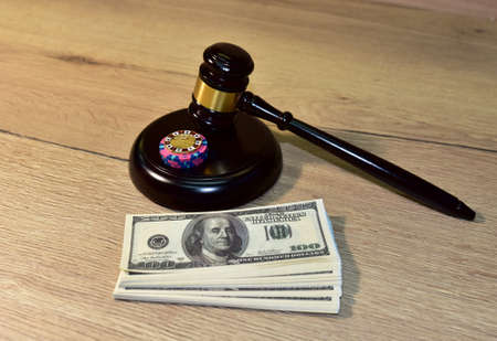 Judge hammer and poker chip for casino game on bundles of dollars. Concept of a court decision in a casino or online poker game ban case. Mallet of judge on law theme and legal system. Poker chipsの写真素材