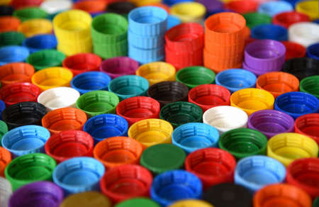 Plastic bottle caps background. Cap material is recyclable.Remove lids from plastic bottles before...