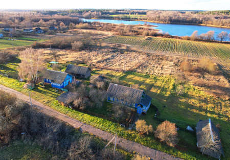 Wooden home in village at lake. Country houses in the countryside. Aerial view of the roofs of rural...