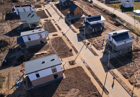 Suburb house construction, aerial viev. Home construction of ceramsite blocks. Construction site of building a country houses. Construction work of laying bricks, gas silicate blocks and roof.の写真素材