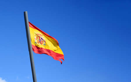 Spain flags on blue sky background. Catalonia Barcelona flag with spain and europe flag.の写真素材
