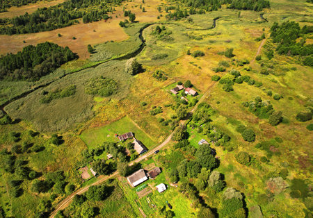Country houses at river in countryside, aerial view. Building a Home in the Country. Village with wooden house. Suburban house in rural on sunset. Rural building and farmhouse at lake in countryside.の写真素材