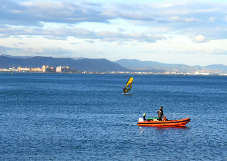 windsurfing sailing. Sailing sport. Surfer on board is surfing in the sea. Surfer catches a wave on a surfboard. Sailing sports on board on waves in sea. Surfer on surfboard.の写真素材