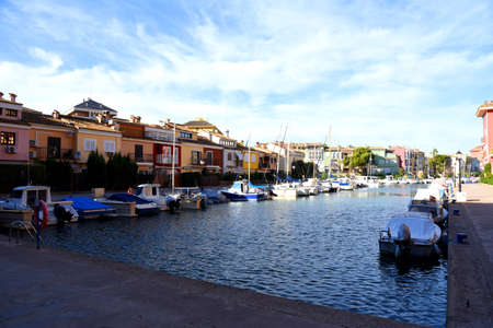 Yachts and motor boats in marina Port Saplaya, Valencia, Alboraya, Spain. Luxury yacht and fishing motorboat in yacht club on the background of the colorful houses at Mediterranean Sea. Sailing port.の写真素材