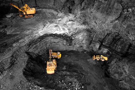 Coal mining in an open pit. Mining excavator loads coal in haul truck in quarry. Excavator digging...