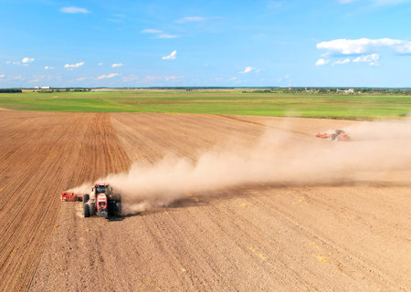 Cultivated land and soil tillage. Tractor with disc cultivator on land cultivating. Agricultural...