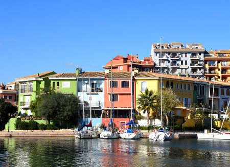 Jetty yacht. Yachts and motor boats in marina Port Saplaya, Valencia. Yacht and fishing motorboat in yacht club. Colorful houses with apartments on Mediterranean Sea coast. Sailboat near pier.の写真素材