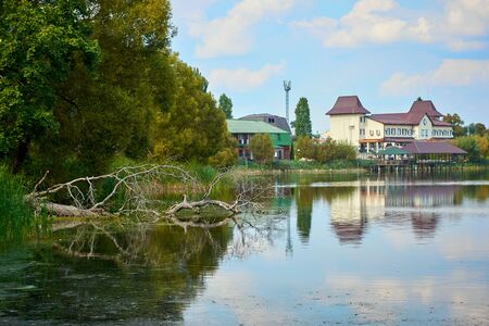 River house with reflections and blue sky near the forestの写真素材