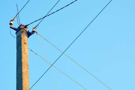 Power line post with electric cables against a clear sky. Power lines, power supply