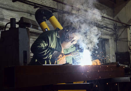 welder at work, bright welding, a lot of smoke going into the hood