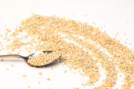 Buckwheat is sprinkled / premium buckwheat groats on white backgroundの写真素材