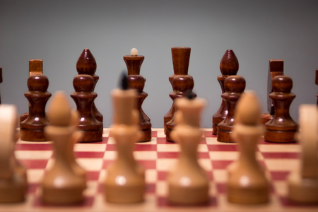 wooden chess board and pieces on a black backgroundの写真素材