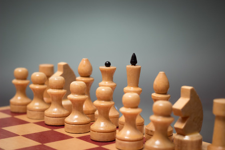 wooden chess board and pieces in white on a gray backgroundの写真素材