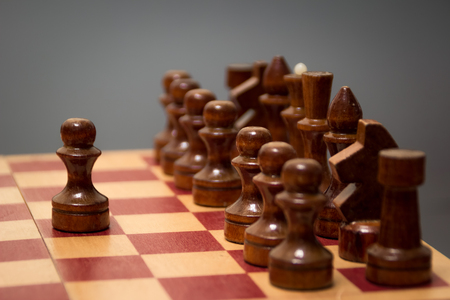 wooden chess board and pieces in black on a gray backgroundの写真素材