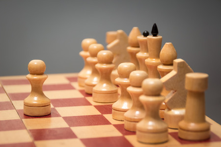 wooden chess board and pieces of white color on a gray backgroundの写真素材