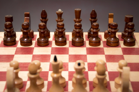 wooden chess board and pieces on a black backgroundの写真素材