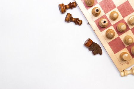 chess board and pieces scattered on the board on a white backgroundの写真素材