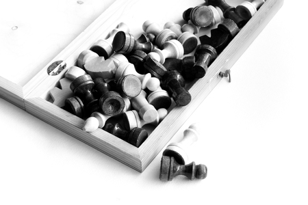 black white chess board and pieces scattered on the board on the black white backgroundの写真素材