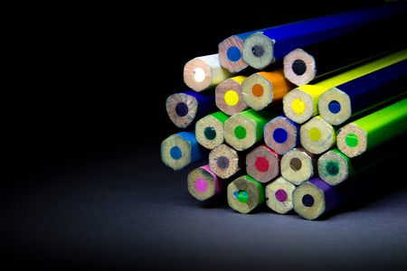 colored pencils on a black background shadowの写真素材