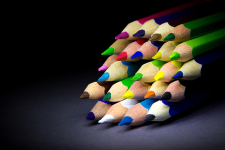 colored pencils on a black background shadowの写真素材