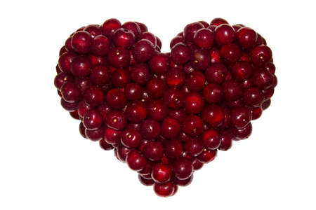 Heart made of ripe red cherries. Isolated on a white backgroundの写真素材