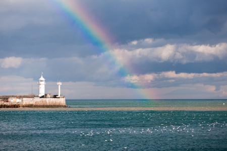 rainbow over the sea and a beaconの写真素材