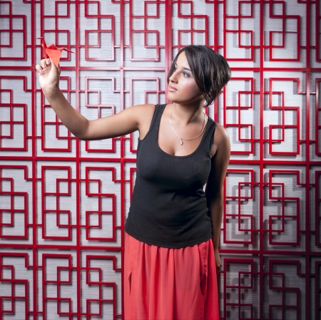 beautiful girl holding paper crane over Red latticeの写真素材