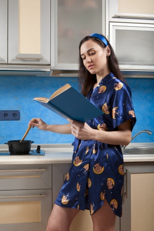 young housewife cooks food in modern kitchenの写真素材