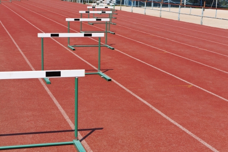 straight lanes of red cinder running track with barriersの写真素材