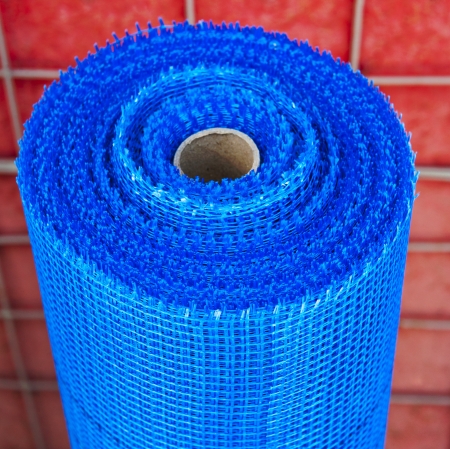 roll of blue plastic mesh on red backgroundの写真素材