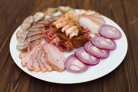 Meat assortment on a square white plate isolated studio shot.の写真素材