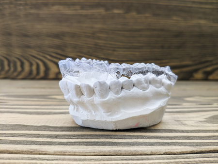 Close-up individual tooth tray Orthodontic dental theme. In hand Invisible braces