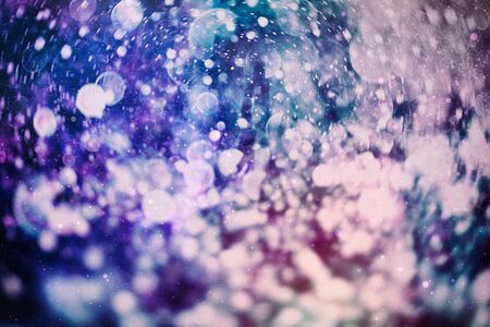 Christmas bokeh glowing Background. Glowing holiday abstract defocused colorful backdrop. Bright...
