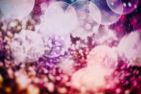 Christmas bokeh glowing Background. Glowing holiday abstract defocused colorful backdrop. Bright...