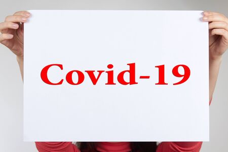 Girl ask for help from coronavirus . Hands on a white background hold a paper asking for help from coronavirusの写真素材