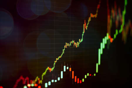 Technical price graph and indicator, red and green candlestick chart on blue theme screen, market volatility, up and down trend. Stock trading, crypto currency background.の写真素材