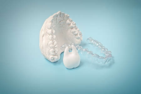 Orthodontic dental theme on blue background. Transparent invisible dental aligners or braces...