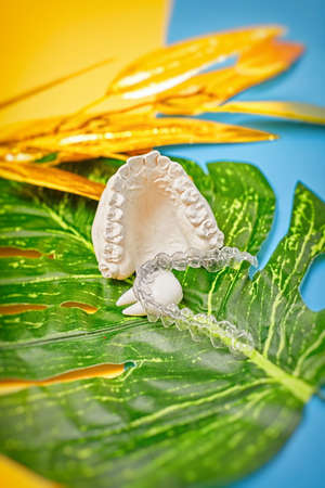 Orthodontic dental theme on blue and yellow background. Transparent invisible dental aligners or...