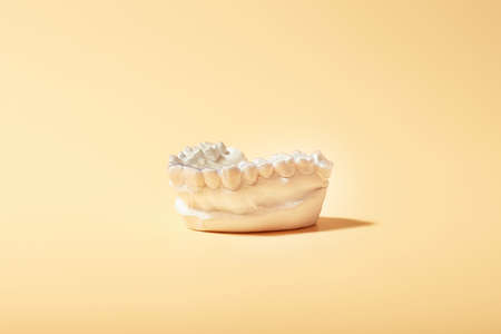 Orthodontic dental theme on yellow background. Transparent invisible dental aligners or braces...