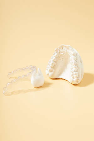 Orthodontic dental theme on yellow background.Transparent invisible dental aligners or braces...