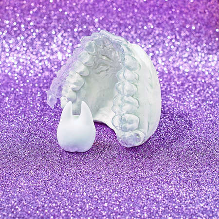 Orthodontic dental theme on yellow background.Transparent invisible dental aligners or braces...