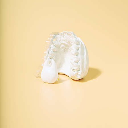 Orthodontic dental theme on yellow background.Transparent invisible dental aligners or braces...