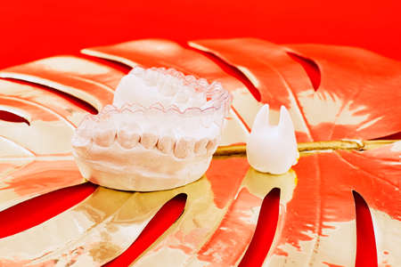 Heart of gold on a red background in invisible dental aligners or braces aplicable for an...