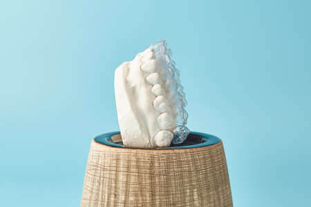Orthodontic dental theme on blue background.Transparent invisible dental aligners or braces...